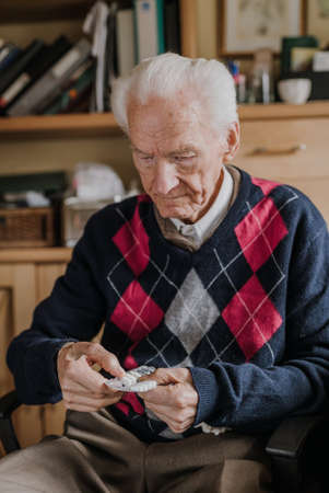 Old man holding medicine blister in handsの写真素材