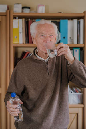 Portrait elderly man drinking waterの写真素材