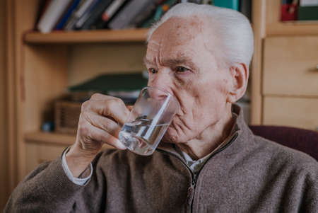 Old man drinking water closeupの写真素材