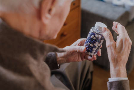 Senior man holding bottle with Pills closeupの写真素材