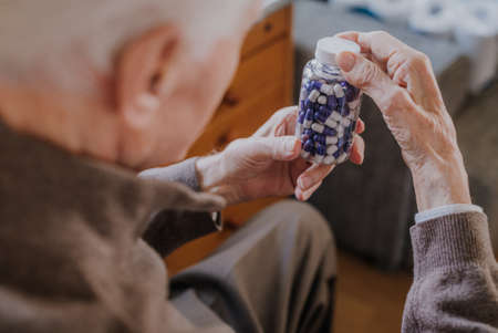 Senior man holding bottle with Pills closeupの写真素材