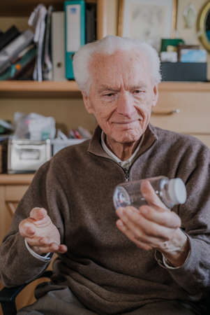 Senior holding an empty medicine bottleの写真素材
