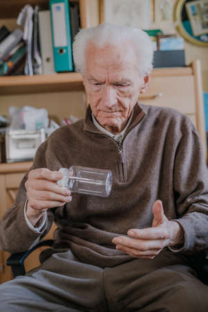 Senior holding an empty medicine bottleの写真素材