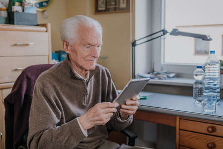 Positive Senior using Digital Tabletの写真素材