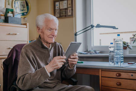 Positive Senior using Digital Tabletの写真素材