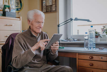 Positive Senior using Digital Tabletの写真素材