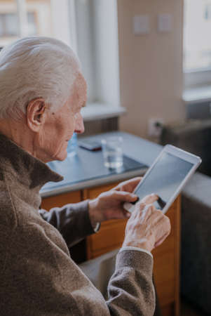Positive Senior using Digital Tabletの写真素材