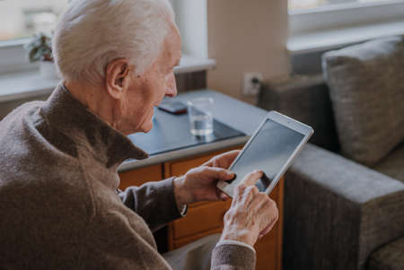 Positive Senior using Digital Tabletの写真素材