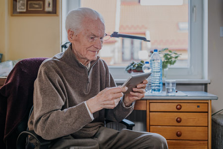 Positive Senior using Digital Tabletの写真素材