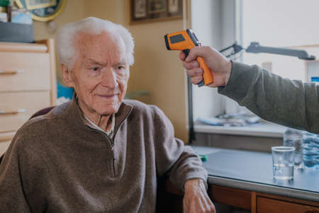 Old man measured temperature with thermometerの写真素材