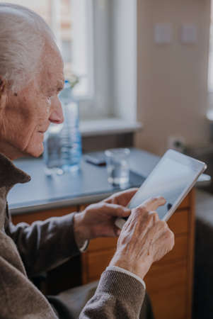 Positive Senior using Digital Tabletの写真素材