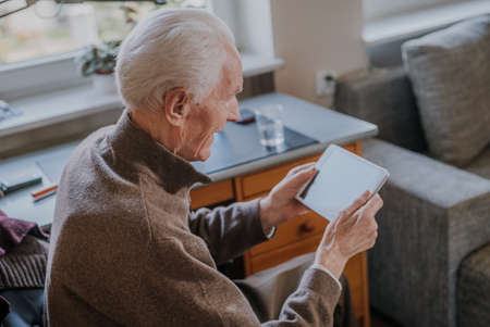 Positive Senior using Digital Tabletの写真素材