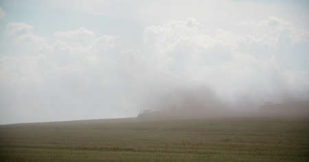 Tractors Blowing Dust On Fieldの写真素材