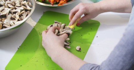 Cuting, slicing mushrooms in the kitchen for cookingの写真素材