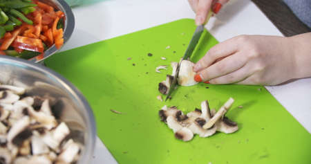 Woman Hand cutting mushrooms fungiの写真素材