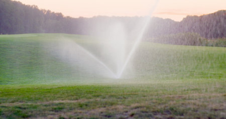 medium shot of grass sprinkler splashes water over the lawnの写真素材