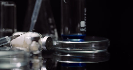 Laboratory Equipement: Syringe and Medicine, Test Tubes and Flasks Rotating on Black Background.の写真素材