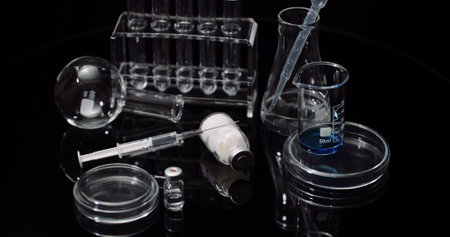Laboratory Equipement: Syringe and Medicine, Test Tubes and Flasks Rotating on Black Background.の写真素材