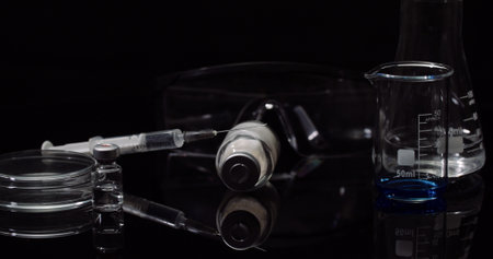 Laboratory Equipement: Syringe and Medicine, Test Tubes and Flasks Rotating on Black Background.の写真素材