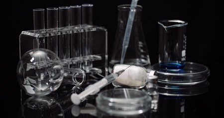 Laboratory Equipement: Syringe and Medicine, Test Tubes and Flasks Rotating on Black Background.の写真素材