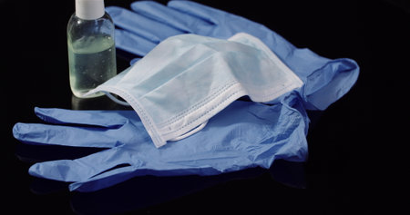Protective Mask Isolated on Black Background Rotating. Medical Mask Protective Gloves.の写真素材
