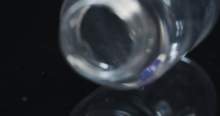 Single Medical Pill in Small Bottle Rotating on Black Background.の写真素材