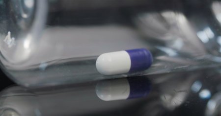 Single Medical Pill in Small Bottle Rotating on Black Background.の写真素材