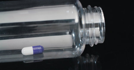 Single Medical Pill in Small Bottle Rotating on Black Background.の写真素材