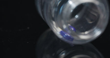 Single Medical Pill in Small Bottle Rotating on Black Background.の写真素材