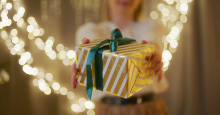 Woman Hands Over a Present and Is Slightly Embarrassedの写真素材