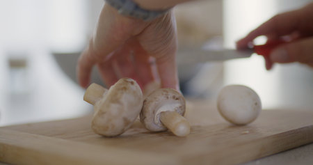 Slow Motion of Mushrooms Falling on Chopping Boardの写真素材