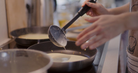 Pouring Pancake Batter into Pan While Fryingの写真素材