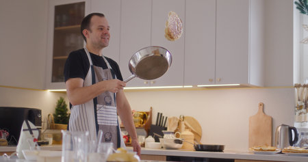 Man Drops Pancake High While Working in Kitchenの写真素材