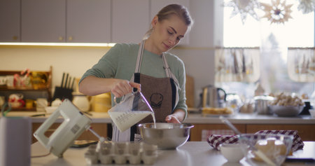 Woman preparing meal in kitchen preparing baked goods workingの写真素材