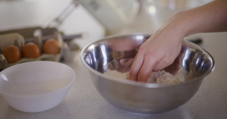 Close-up of chefs hand moving flour with hand preparing doughの写真素材