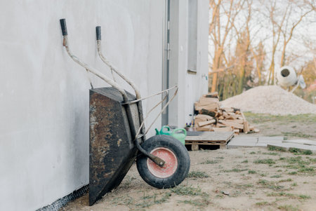 Wheelbarrow leaning against a wallの写真素材