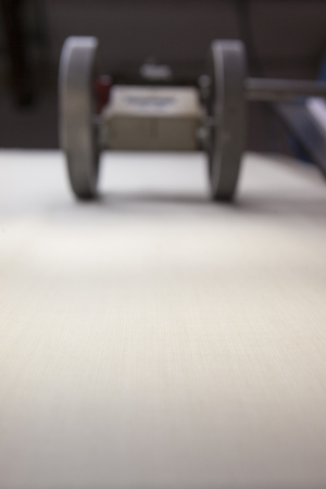 white fabric sliding over a quality controll lamp. with a counting machine measuring the length of a...