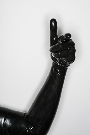 gesture of a hand wearing a black latex glove, thumb upの写真素材