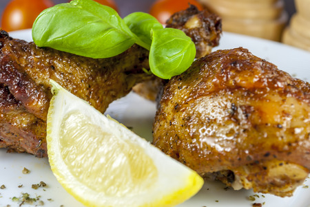 grill chicken with vegetables and cutlery and basil on white plateの写真素材