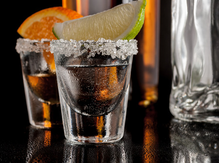 Gold and silver tequila with lime or lemon and orangeの写真素材