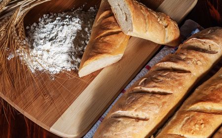 Traditional french baguettes or bread and grain on wood tableの写真素材