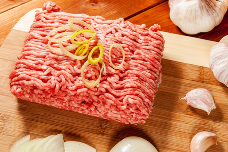 Mincet meat with vegetables on wood plate