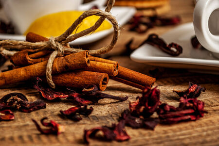 Cinnamon and hibiscus and cup of tea on wood tableの写真素材