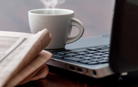 Newspaper and cup of coffee on wood tableの写真素材