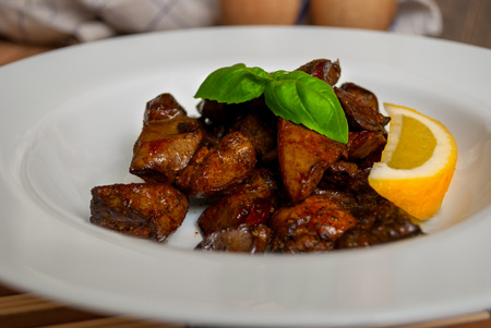 Grilled livers on white plate with basil