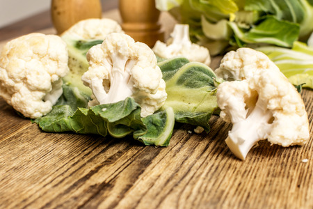 Raw cauliflower with leaf on wood tableの写真素材