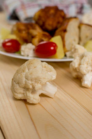 Raw cauliflower with fried cauliflower and potatoes and tomatoesの写真素材