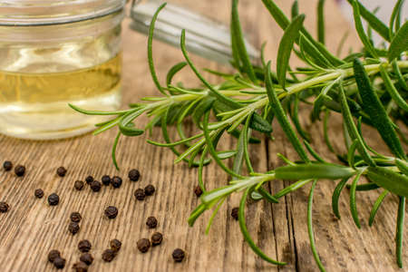 Herb rosemary with oil on wood tableの写真素材