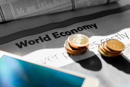 Coins and newspaper with inscription world economy