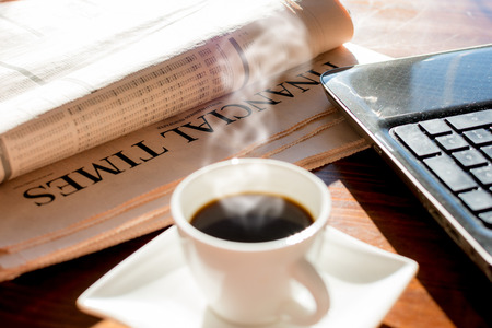 Coffee and notebook and newspaper with inscription financial timeの写真素材